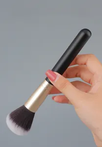 Detail of premium makeup brush featuring natural wood handle and comfortable grip