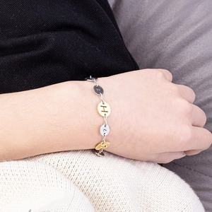 Dettaglio del bracciale in acciaio inossidabile bicolore oro e argento con incisioni