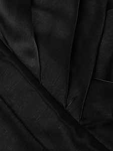 Detailed close-up of glossy black satin fabric with elegant vertical pleats and texture