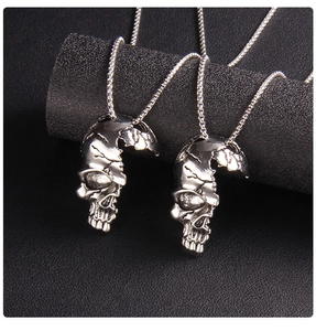 Gros plan de pendentifs tête de mort en acier inoxydable punk avec texture fissurée
