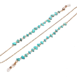 Detail of bohemian gold chain eyeglass strap with turquoise stones and non-slip rubber ends
