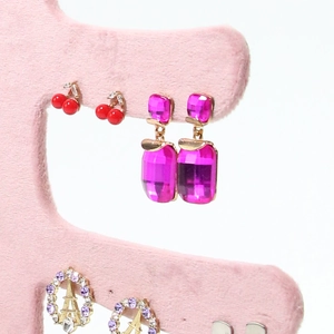 Pink velvet jewelry display stand with gemstone drop earrings and cherry studs