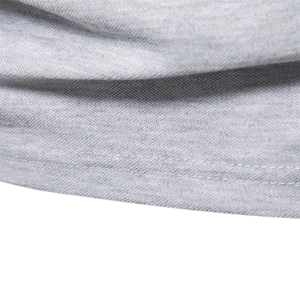 Gros plan sur un polo en coton gris montrant la maille et l'ourlet à double couture