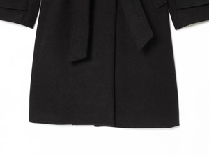 Detailed macro view of the black wool coat hem and matching fabric waist belt tie