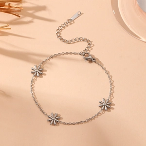 Silver daisy bracelet with O-chain and lobster clasp on a minimalist aesthetic background