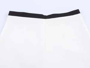 Détail de la taille bicolore contrastée avec des coutures précises sur tissu blanc
