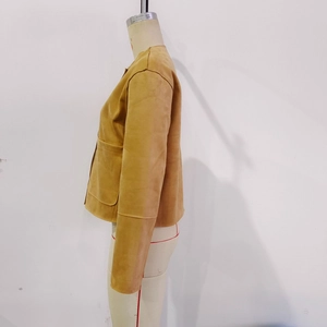 Détail de la veste courte en daim camel avec col rond et poches plaquées sur le devant