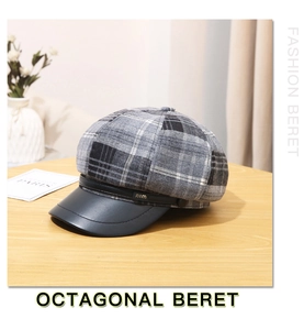 Detail of grey plaid wool octagonal beret with black leather brim and metal logo