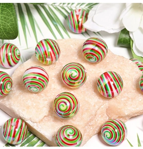 Macro view of colorful striped acrylic round beads on a natural stone and floral background