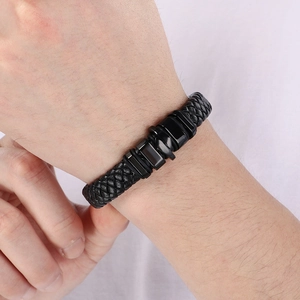 Dettaglio del bracciale in pelle intrecciata nera con chiusura magnetica al polso