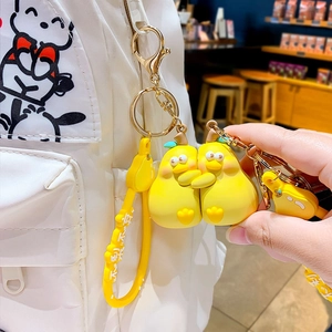 Cartoon pear duck keychain with yellow wrist strap on a white canvas bag