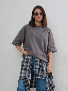 Dettaglio maglietta oversize in cotone grigio scuro con spalle scese e stile casual urbano