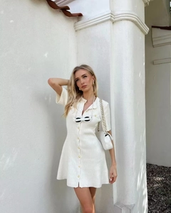 Detailed view of white short sleeve knitted dress with button front on professional model