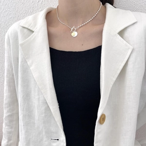 Detail of 925 silver beaded necklace featuring a yellow smiley face and OT toggle clasp