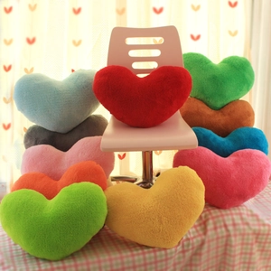 Colorful heart-shaped plush pillows stacked on a chair for modern home sofa decoration