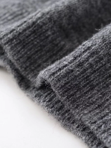 Macro della texture in maglia grigio scuro con fibre di lana e cuciture a coste fini
