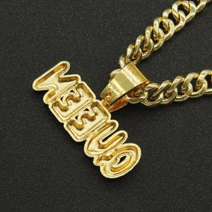 Close-up of golden Cuban chain with iced-out WEBUD letter pendant on dark background
