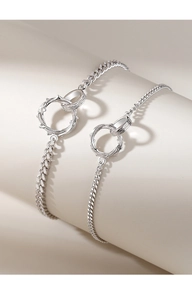 Macro detail of interlocking Mobius silver rings on a textured chain couple bracelet
