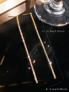 Detail shot of 11.5cm long gold tassel earrings with sparkling white cubic zirconia