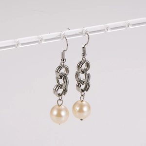 Elegant stainless steel silver chain link earrings with white pearl drop on display stand