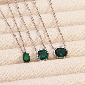 Three elegant silver necklaces with pear, square, and oval green emerald stone pendants