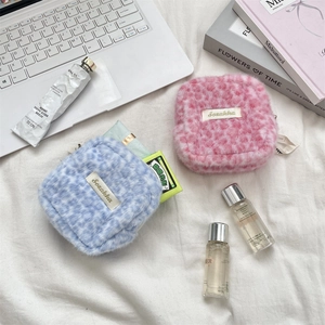 Close-up of leopard print plush storage bags in pink and blue with zipper closure