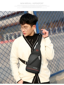 Outdoor shot of a black oxford crossbody bag with red detail and adjustable strap