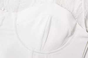 Close-up of white lace stitching and textured twill fabric on sexy bodice top