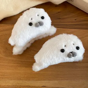 Pair of cute plush seal hair claws in white faux fur for winter hair styling