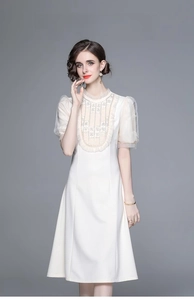 Détail d'une robe blanche élégante avec broderie perlée et manches bouffantes en organza