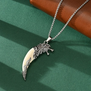 Close-up of a silver wolf head pendant with an off-white fang on a box chain necklace