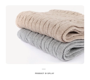 Detailed close-up of khaki and grey thick cable knit texture for winter accessories