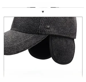 Detail view of dark grey winter baseball cap featuring thickened wool-like fabric and earflaps