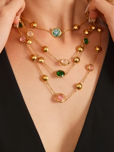 Close-up of four-layer bohemian gold necklace with multi-colored faceted gemstones