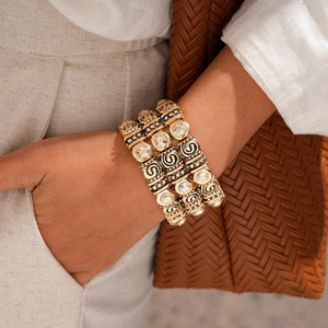 Detail of bohemian gold stackable cuff bracelet with vintage spiral texture and crystals