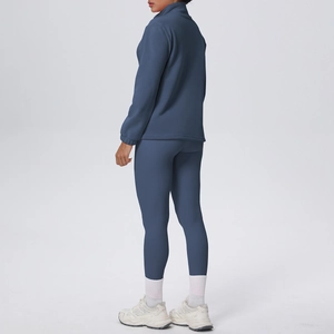 Dettaglio dei leggings a vita alta e della giacca sportiva blu scuro in tessuto compressivo