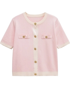Close-up of pink knit cardigan with contrasting white trim and golden embossed buttons