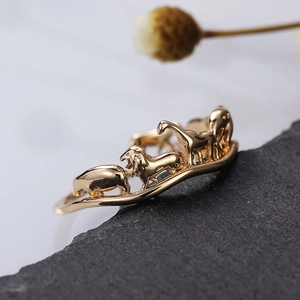 Japanese style gold plated circus animal relief ring on a textured grey stone base