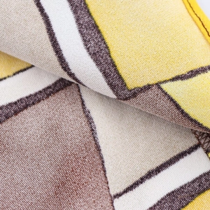 Macro di morbido tessuto a maglia con motivi geometrici gialli e marroni per completo