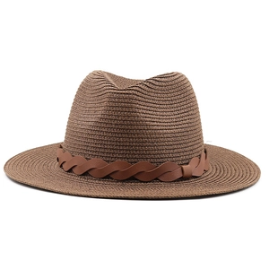 Close-up of the textured straw weave and brown braided leather band on the fedora