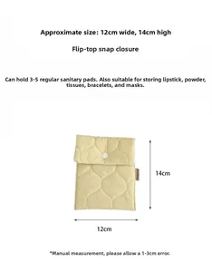 Macro view of light yellow quilted sanitary pad bag with white snap button and size labels