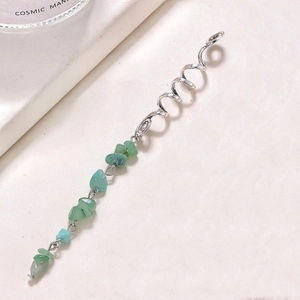 Detailed view of silver spiral hair coil with natural green stone charm for dreadlocks