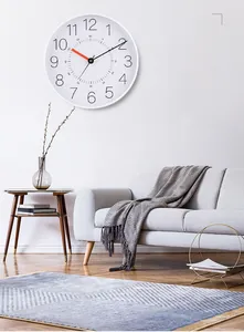 Detail of 12-inch silent wall clock with orange second hand in a modern living room