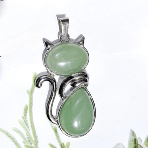 Detail of silver cat pendant with light green crystal gemstones and curved tail