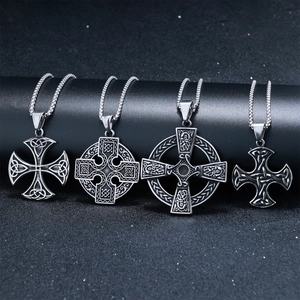 Macro view of four silver stainless steel Celtic knot cross pendants on a dark base