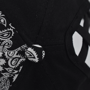 Detailed macro view of black twill cotton baseball cap with paisley pattern patchwork