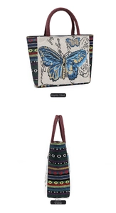 Close-up of ethnic embroidered canvas bag with blue butterfly pattern and colorful straps