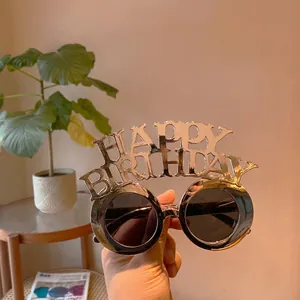 Close-up of golden Happy Birthday party glasses with large round black lenses