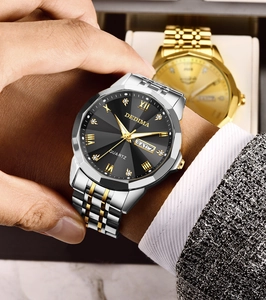 Macro detail of luxury steel watch with gold accents and Roman numeral markers