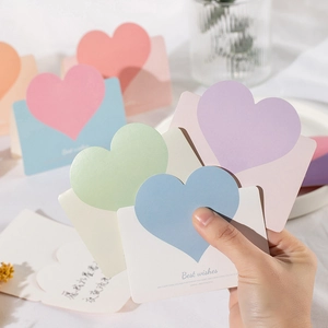 Macro view of colorful heart-shaped greeting cards in pastel pink, blue, and purple tones